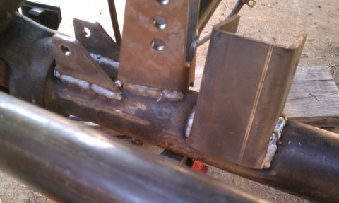 1990 Ford Bronco - Custom metal brackets are welded onto a vehicle's axle for modification.