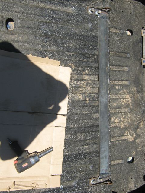 1978 Ford Bronco - A metal bar and an impact wrench are visible on the textured floor of a truck bed.