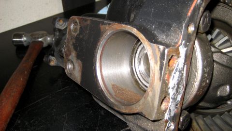 1996 Ford Bronco - A hammer rests near a differential housing, showing signs of wear and rust.
