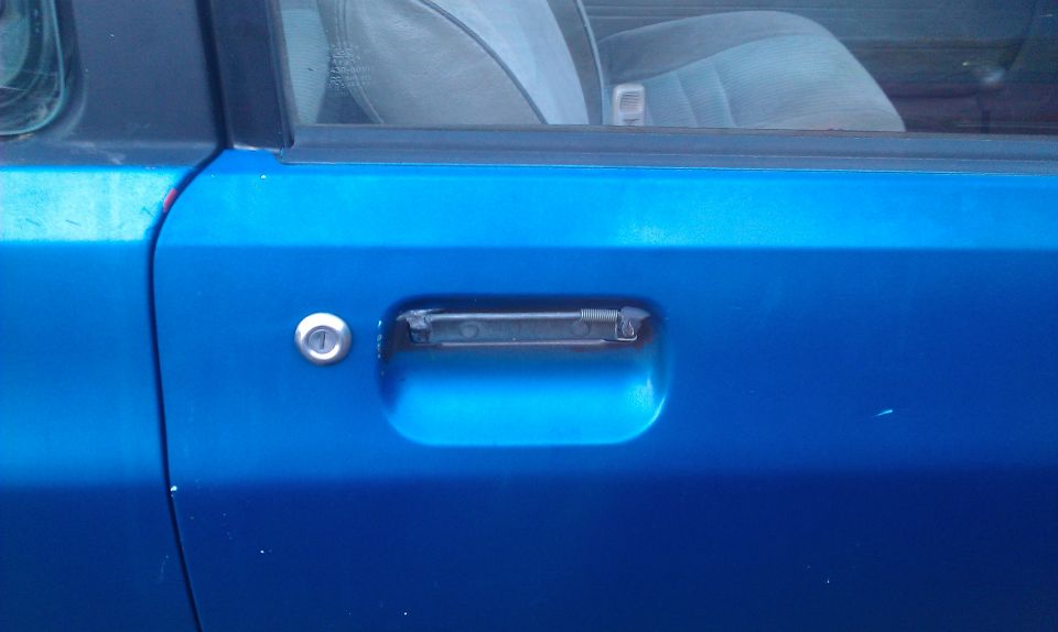 Blue car door with a chrome lock cylinder and a black interior door handle