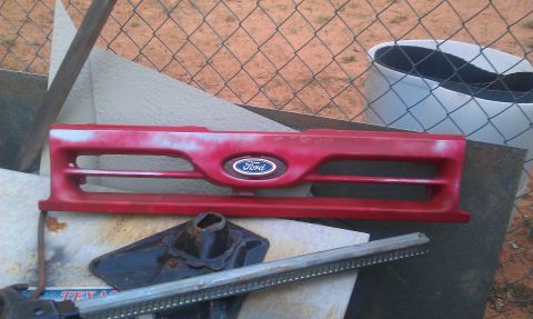 1991 Ford Festiva - This is a Ford grille, possibly from a 1991 model, with a jack visible underneath.