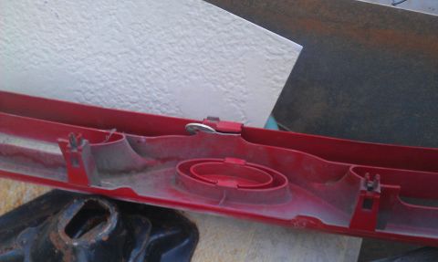 1991 Ford Festiva - A red plastic trim piece with mounting hardware is shown, possibly from a vehicle.