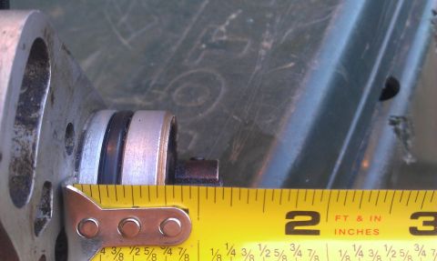 1991 Ford Festiva - A yellow tape measure is used to measure a metal component, showing measurements in inches.