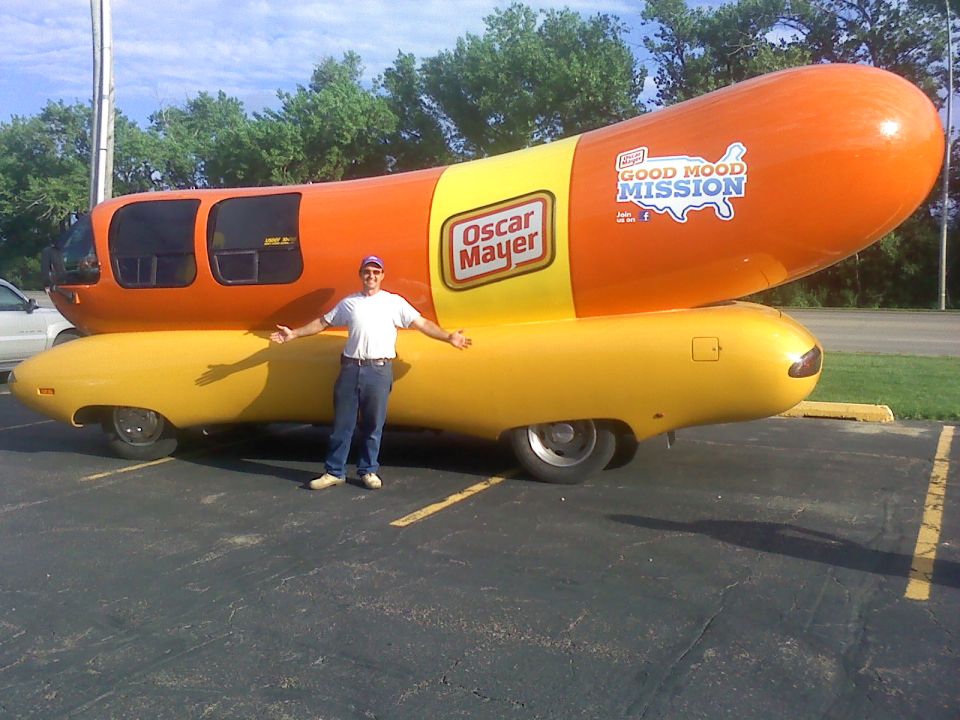 Guy standing next to an Oscar Mayer Wienermobile