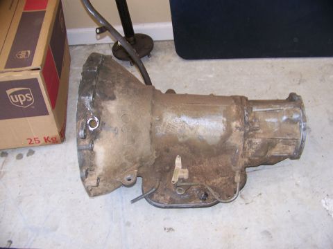 1992 Jeep YJ - A used transmission part is shown on a concrete floor with a UPS box in the background.