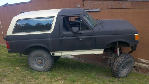 1988 Ford Bronco - This modified Ford Bronco features a two-tone paint scheme and appears to be undergoing some form of customization or repair.