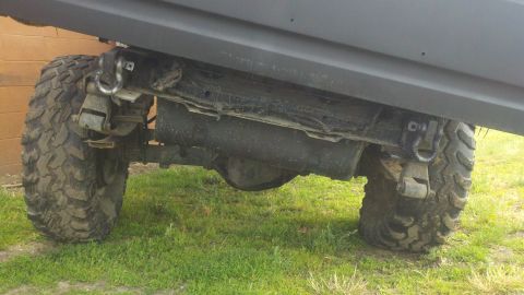 1988 Ford Bronco - The underside of a heavily modified off-road vehicle shows its suspension and large tires.