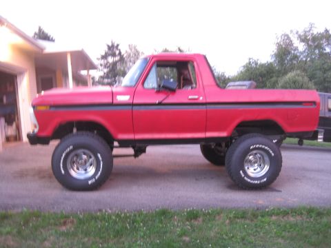 1979 Ford Bronco - Side view of a red 1979 Ford Bronco with a lifted suspension and off-road tires.
