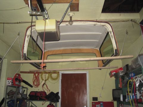 1979 Ford Bronco - A vehicle's removable hardtop is stored overhead in a garage, supported by a makeshift pulley system.
