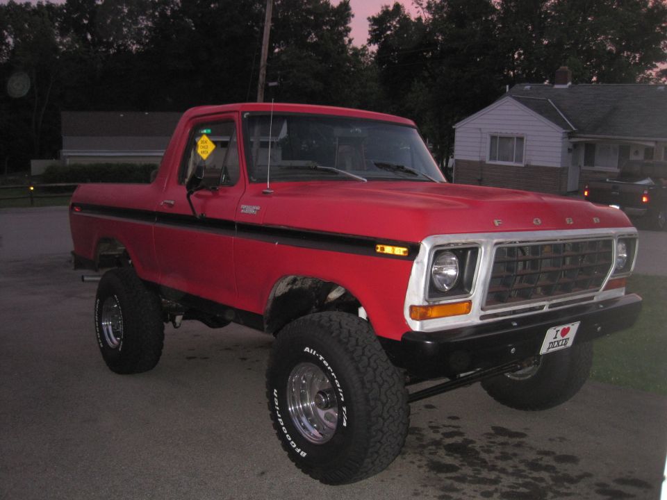 Red lifted 1978-79 Ford F-100 short-bed 4x4 pickup parked at dusk