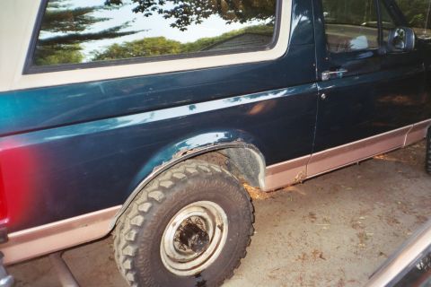 1994 Ford Bronco - This Ford Bronco shows significant rust on the rear fender and rocker panel, indicating an earlier model year than claimed.