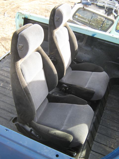 1978 Ford Bronco - Interior view of two car seats installed in the bed of a blue vehicle.