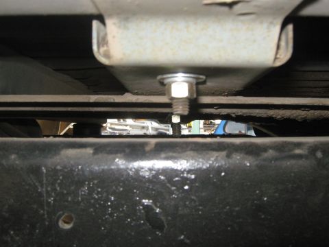 1978 Ford Bronco - A close-up shot of the undercarriage reveals a bolted connection, with other vehicles blurred in the distance.