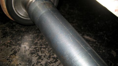 1996 Ford Bronco - Close-up of a metal shaft with a ribbed texture and a wheel hub is visible.