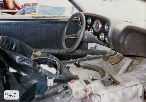 1973 Ford Mustang - The interior of a 1973 Ford Mustang shows modifications for racing, including a roll cage and custom gauges.