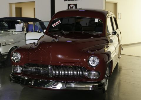 2006 Cadillac STS - A maroon custom wagon is displayed with a "SOLD" sign on its windshield, parked next to another vehicle.