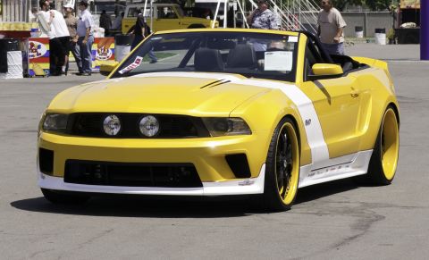 2006 Cadillac STS - This yellow convertible Ford Mustang features white racing stripes and custom wheels.
