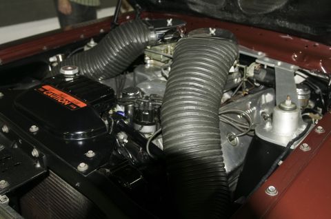 2006 Cadillac STS - Close-up of an engine bay dual carburetors and prominent air intake hoses.