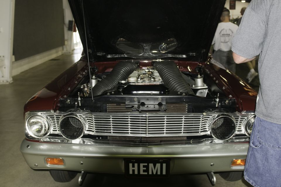 Front view of a classic car with hood open, showing dual air intakes and a HEMI license plate