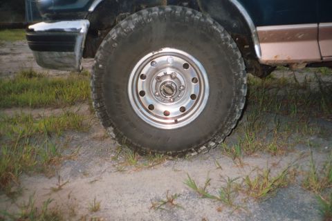 1994 Ford Bronco - The front wheel and fender of a 1994 Ford Bronco are visible in this close-up shot.