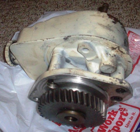 1980 Ford Bronco - This is a used power steering pump with a gear, placed on white plastic packaging.