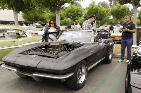 2006 Cadillac STS - A black 1963 Corvette convertible is displayed with its hood open, revealing the engine, while people stand nearby.