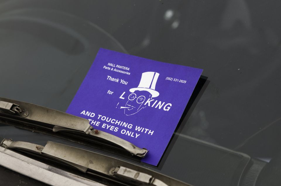 Purple Hall Pantera 'look with your eyes only' show card under a chrome windshield wiper