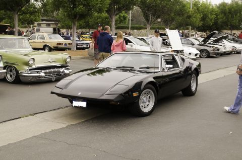 2006 Cadillac STS - A black De Tomaso Pantera is parked at an outdoor car show with other vehicles visible.