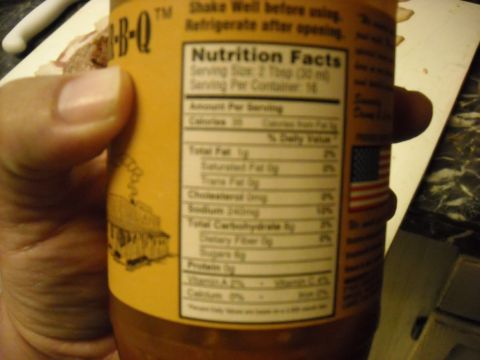 1979 Ford F-150 - A bottle of BBQ sauce is held in a hand, showing its nutrition facts label and a small illustration.