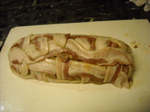 1979 Ford F-150 - A meatloaf wrapped in bacon sits on a white cutting board, ready for cooking.