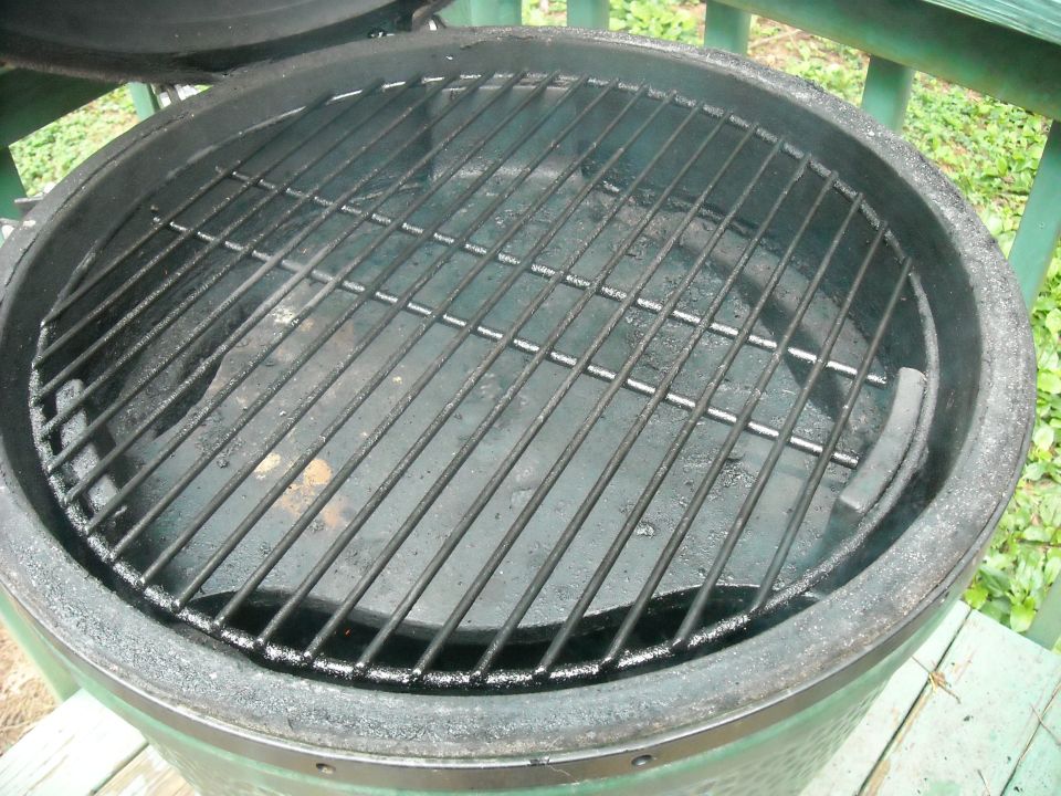 Close-up of a green charcoal grill with metal grates