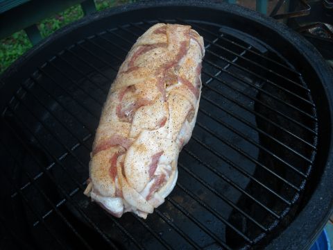 1979 Ford F-150 - A meatloaf, wrapped in bacon and seasoned, sits on a black grill grate, ready for cooking.