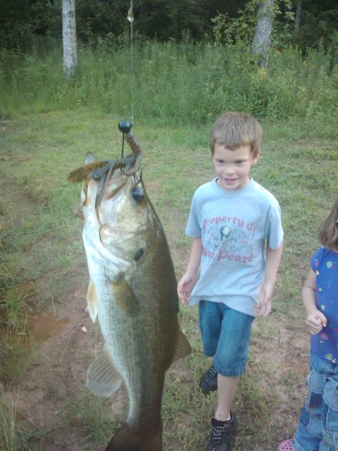 1989 Ford Bronco - A boy proudly displays a large bass caught while fishing.