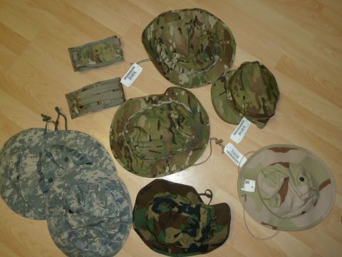 1992 Ford Mustang - A collection of military-style hats and pouches are laid out on a wooden surface, displaying different camouflage patterns.