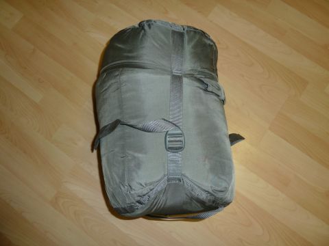 1992 Ford Mustang - Olive green sleeping bag with straps and buckle, shown on a wooden floor.