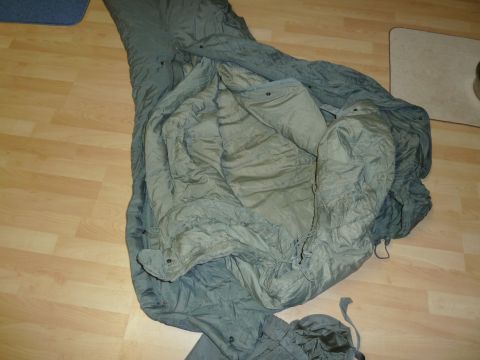 1992 Ford Mustang - A military sleeping bag is spread open on a light wood floor.