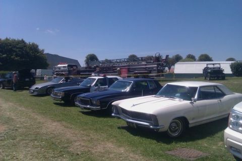 1991 Ford LTD Crown Victoria - A collection of vintage vehicles are displayed outdoors on a sunny day, with a fire truck and other vehicles visible.