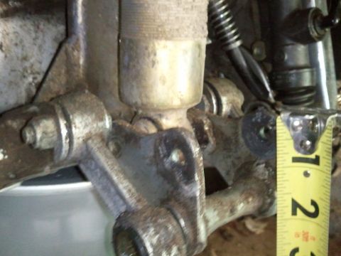 1985 Ford F-150 - A close-up view of a vehicle's suspension part, with a tape measure for scale.