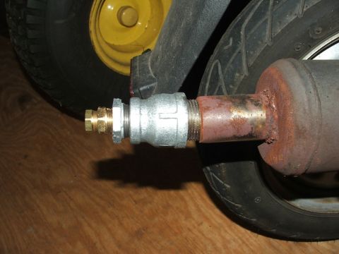 2008 Yamaha Zuma - Custom exhaust modification on a scooter, showing a brass fitting and rusty pipe.