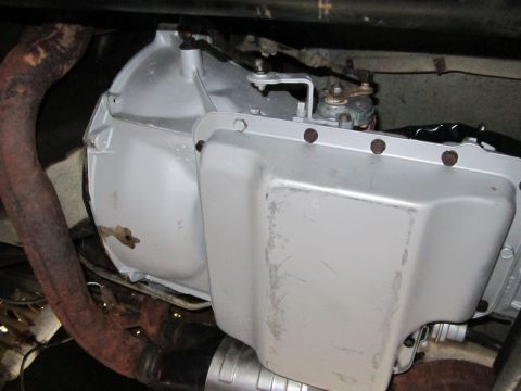 1989 Ford Bronco - Underside view of a vehicle's transmission pan and exhaust system, with visible rust on the exhaust pipe.
