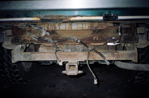 1994 Ford Bronco - The rear bumper and trailer hitch assembly of a 1994 Ford Bronco, showing some rust and exposed wiring.