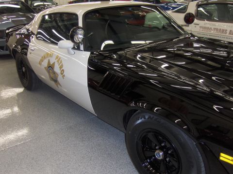 1979 Chevrolet Camaro - This police car, likely a 1977 Chevrolet Camaro, features a distinctive black and white paint scheme and highway patrol markings.