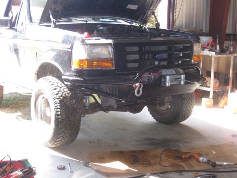 1994 Ford Bronco - Front view of a black 1994 Ford Bronco, an aftermarket bumper and winch, with the hood open.