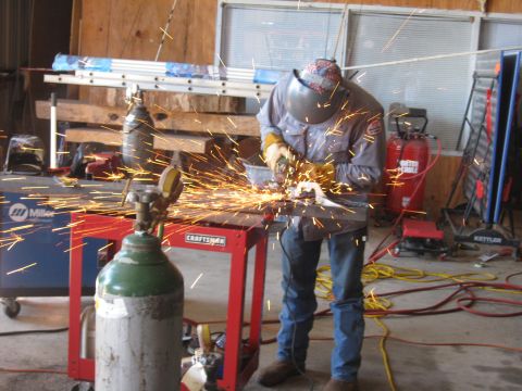 1994 Ford Bronco - Grinding metal in a workshop setting with sparks flying everywhere.
