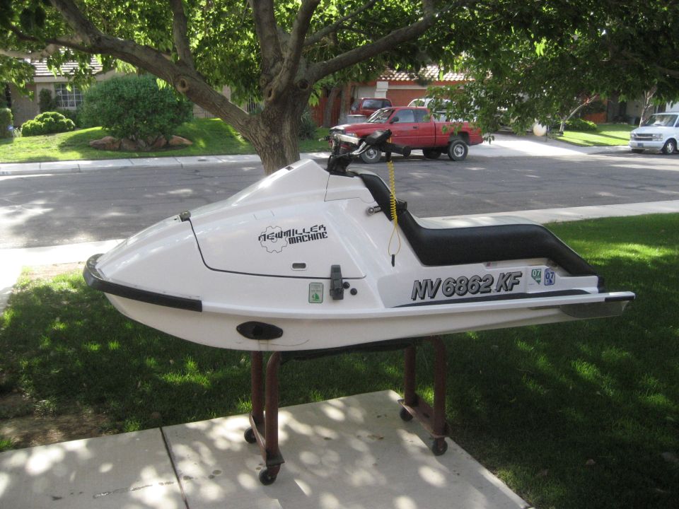White stand-up jet ski personal watercraft on wheeled stand in driveway