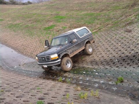1994 Ford Bronco - This 1994 Ford Bronco is navigating a challenging, wet, textured slope.