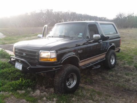 1994 Ford Bronco - This 1994 Ford Bronco is shown with its driver's door open, parked outdoors on a slightly overcast day.