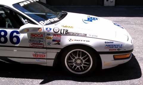 1990 Ford Probe - A white race car with numerous sponsor decals and the number 86 is seen from a three-quarter front angle.