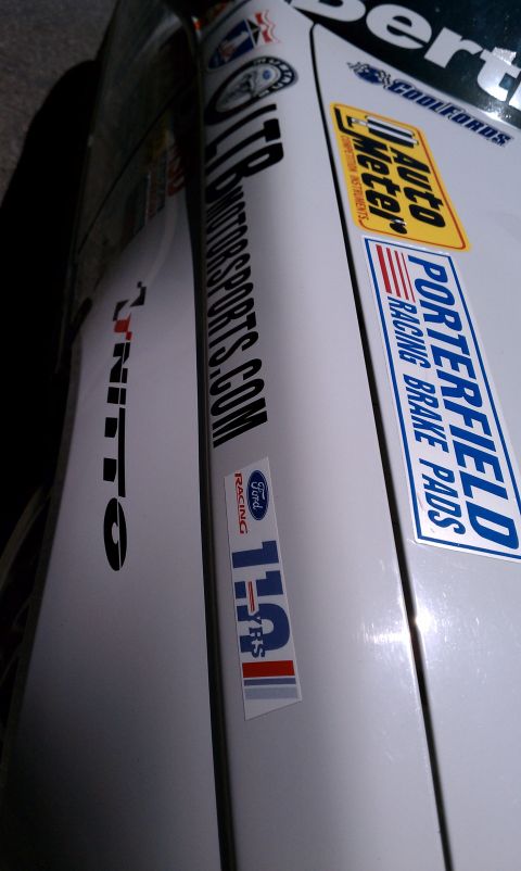 1990 Ford Probe - A white car displays numerous racing decals on its side, including Porterfield Racing Brake Pads and Auto Meter.