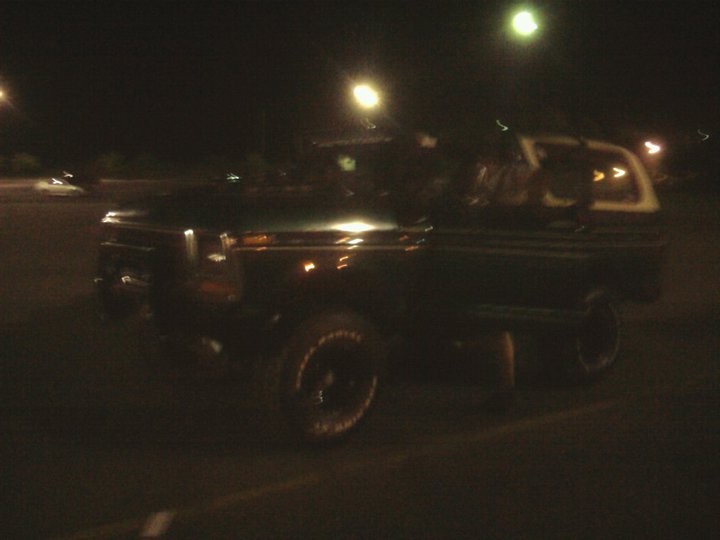 Dark SUV with white top, 3/4 front view at night. Matches 1979 Ford Bronco